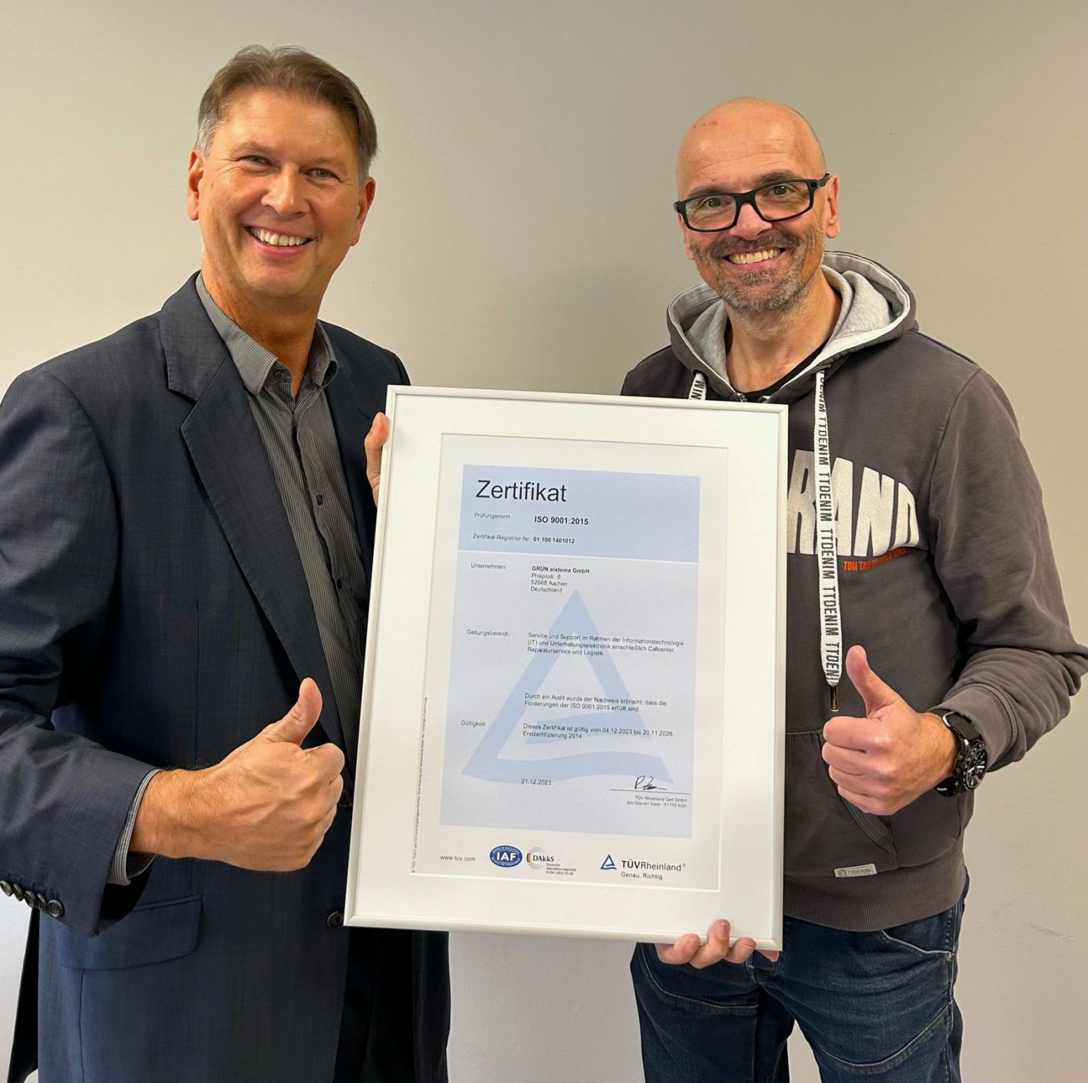Der TÜV Rheinland, vertreten durch Ralph Freude (links), überreicht Oliver Roßbruch, CEO der GRÜN aixtema GmbH, das DIN ISO 9001:2015 Zertifikat.